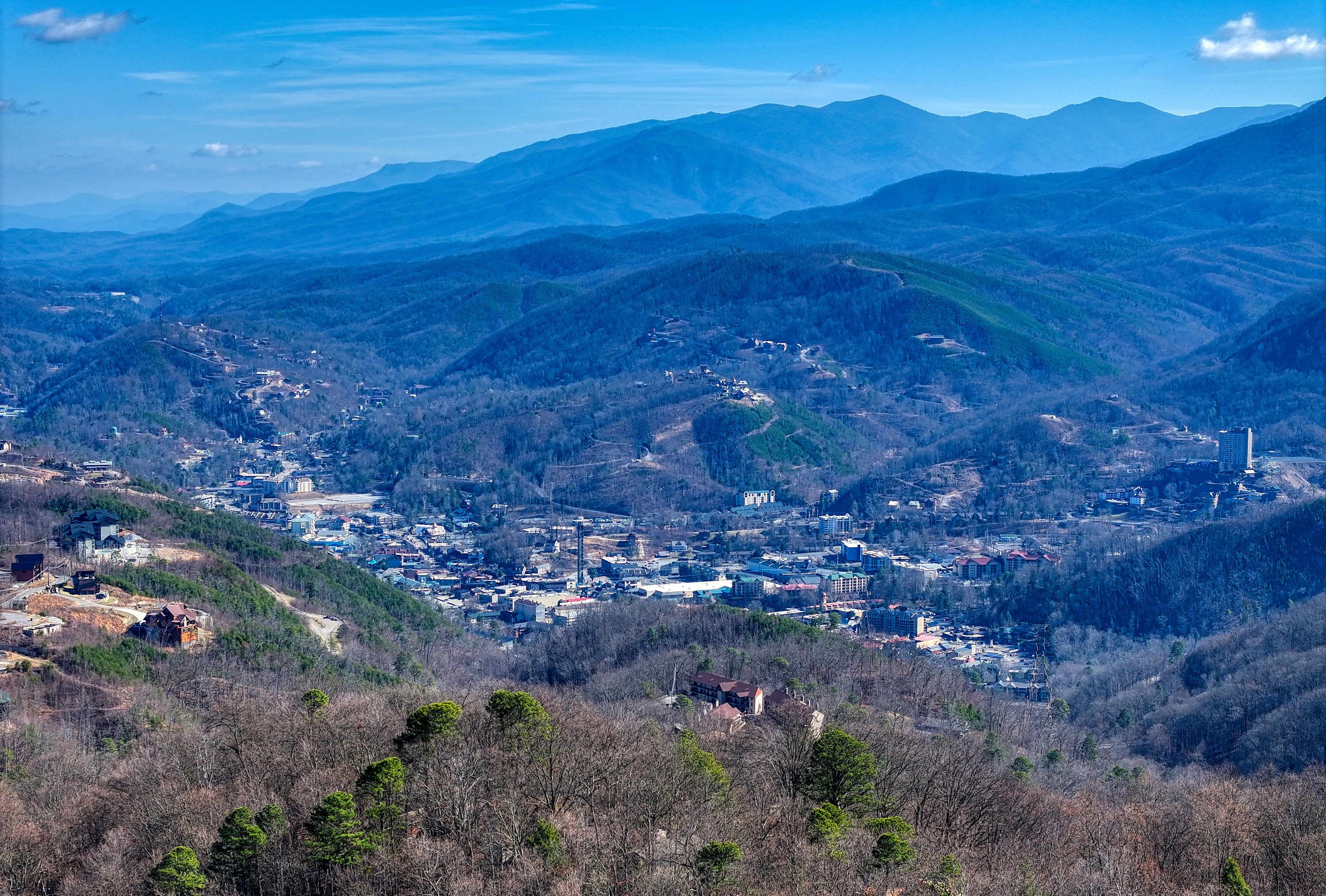 A town nestled in a valley surrounded by mountains, with a mix of residential and commercial buildings.