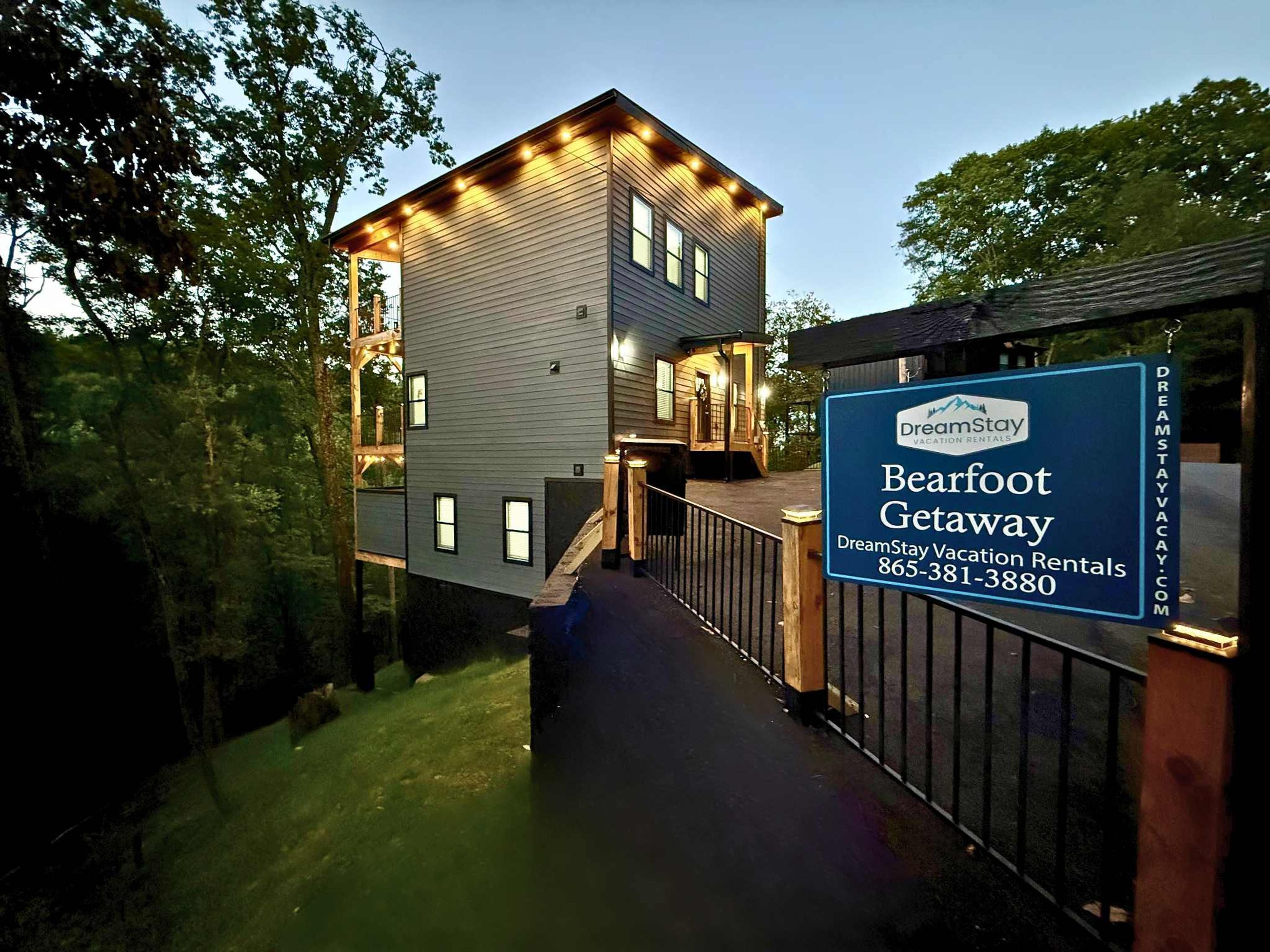 A two-story building with a balcony, a signboard for DreamStay Vacation Rentals, and a contact number.