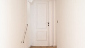 A staircase leading to a white door with a doorknob and a small metal plate.