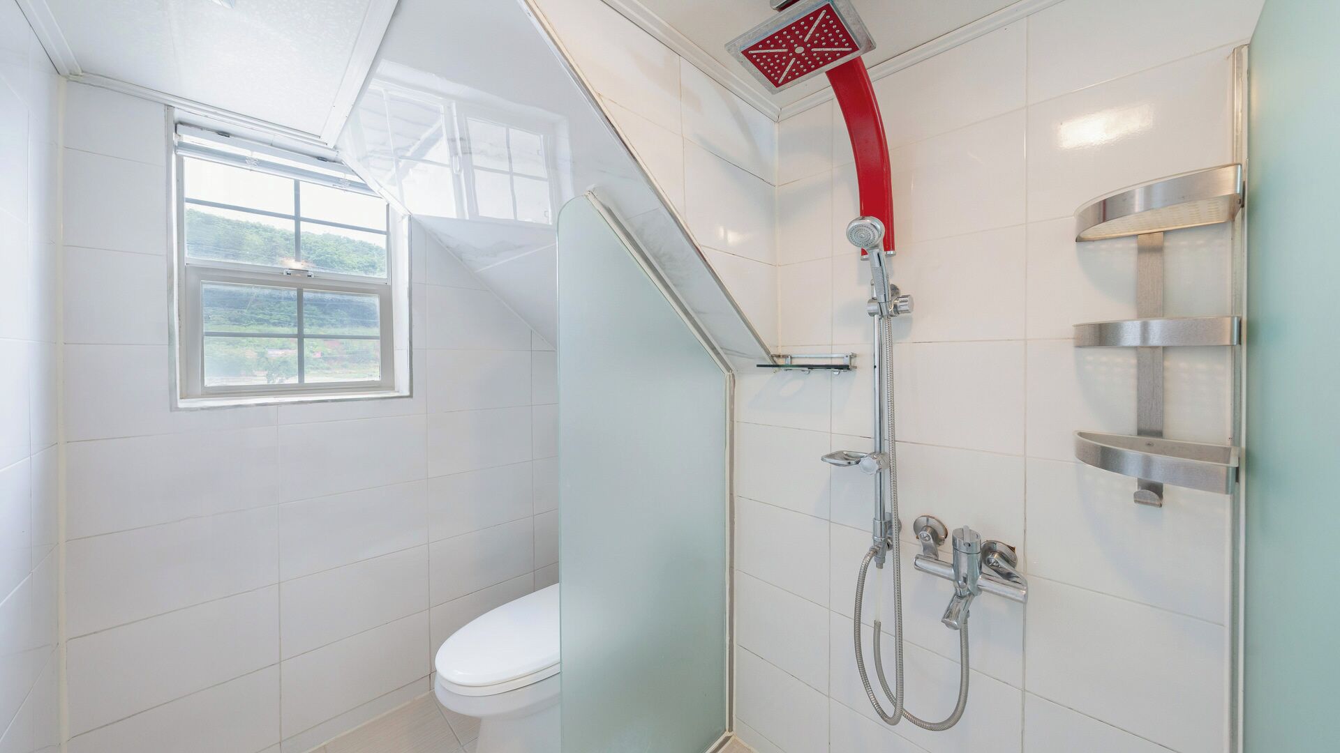 Une salle de bain moderne équipée d’une douche, de toilettes et d’une fenêtre.