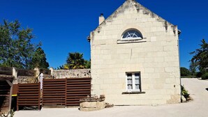 Un pequeño edificio de piedra con techo inclinado y una única ventana en arco.