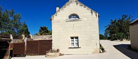 A small stone building with a pitched roof and a single arched window.