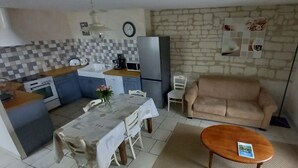 Un espacio habitable pequeño con kitchenette, comedor y sofá.