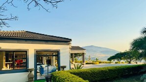 A modern house with a patio, a gazebo, and a view of mountains. - Dwaleni Farm Lodge (Matsapha)