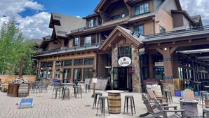 A lodge with a stone facade, multiple windows, and outdoor seating areas. - 1-bedroom condo Grand Lodge @ Peak 7 in fantastic Breckenridge with fitness room (Breckenridge)