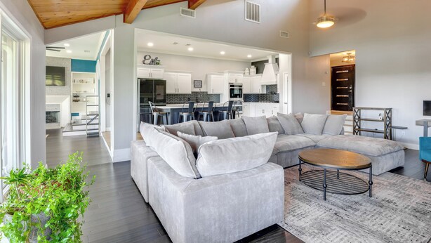 A spacious living area with a large sectional sofa, a round coffee table, and a view into the kitchen. - Outdoor Oasis w/ Lake Views: Ransom Canyon Retreat (Ransom Canyon)