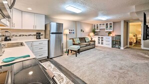A compact kitchen with white cabinets, a refrigerator, and a coffee maker. - Modern Salt Lake City Apt.- 20mi to Snowbird! (Salt Lake City)