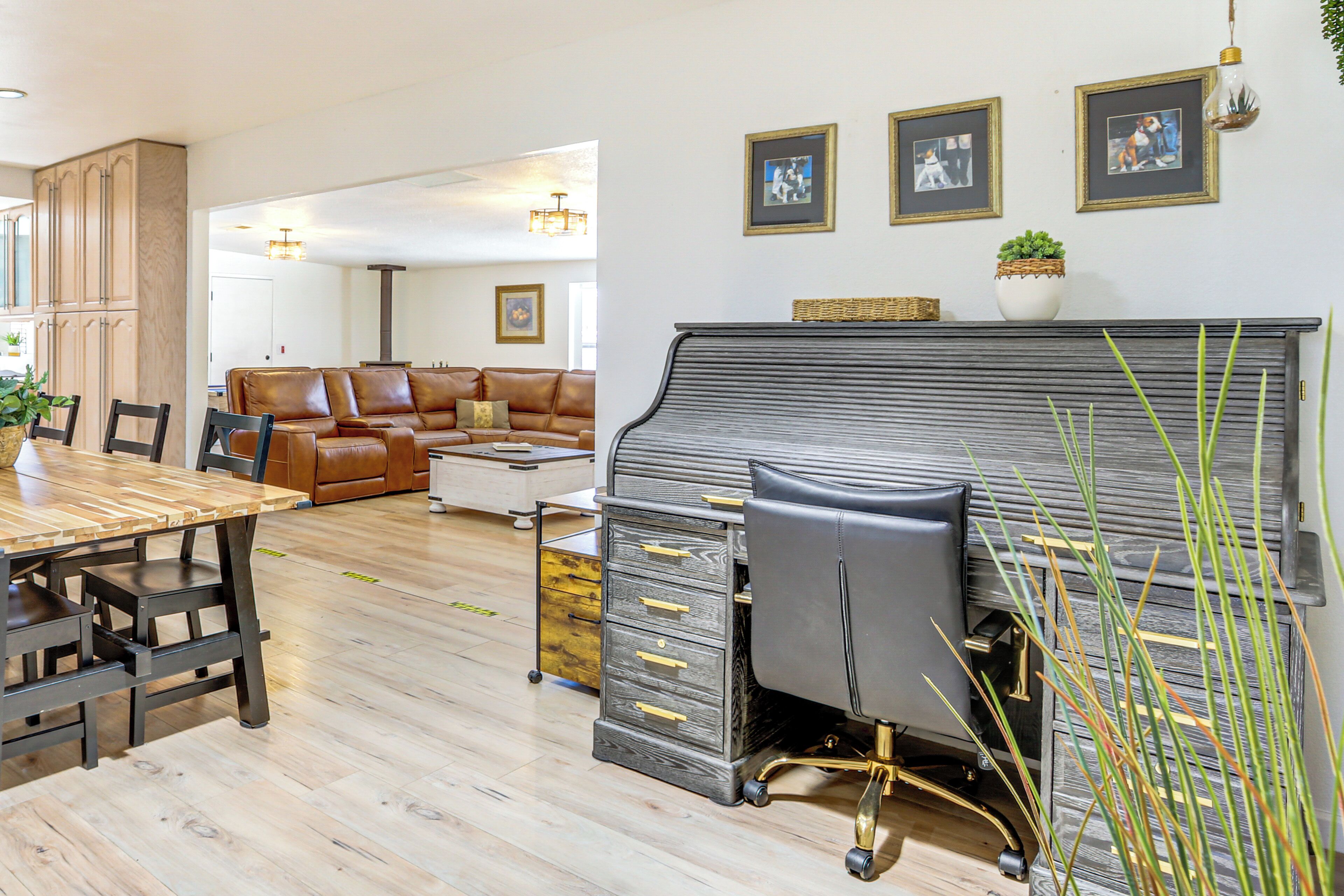 Een ruime woonkamer met een eettafel, leren bank en een piano.