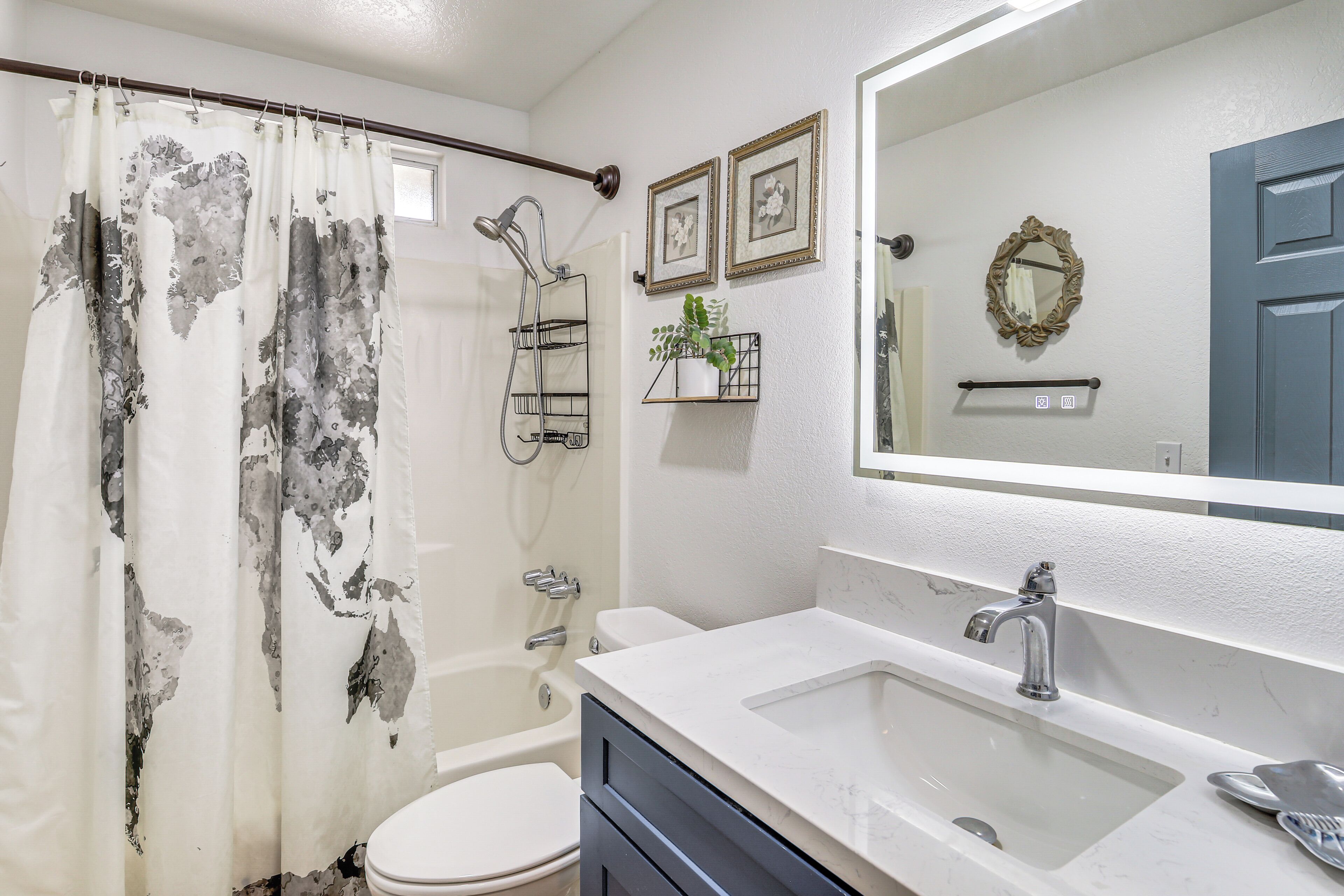 Une salle de bain équipée d’une douche, de toilettes, d’un lavabo et d’un grand miroir.
