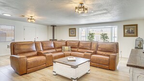 A spacious living room with a large L-shaped leather sectional sofa, a white coffee table, and a fireplace. - 9 Mi to Joshua Tree NP: Yucca Valley Home w/ Pool (Yucca Valley)