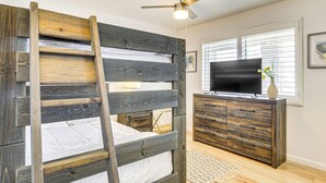 A bunk bed with a ladder, a wooden dresser, a flat-screen TV, and a window with blinds. - 9 Mi to Joshua Tree NP: Yucca Valley Home w/ Pool (Yucca Valley)