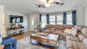 A living room with a sectional sofa, a coffee table, and a television on a stand. - Outdoor Kitchen + Hot Tub: Table Rock Lake House (Golden)