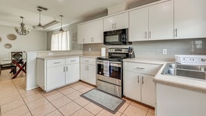 A modern kitchen with white cabinets, stainless steel appliances, and a granite countertop. - 4 Mi to Dtwn Brownsville: Family Home w/ Yard! (Brownsville)