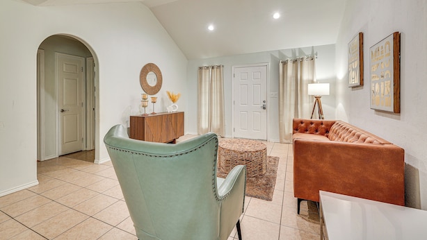 A spacious living room with a high ceiling, a large window, and a modern sofa. - 4 Mi to Dtwn Brownsville: Family Home w/ Yard! (Brownsville)