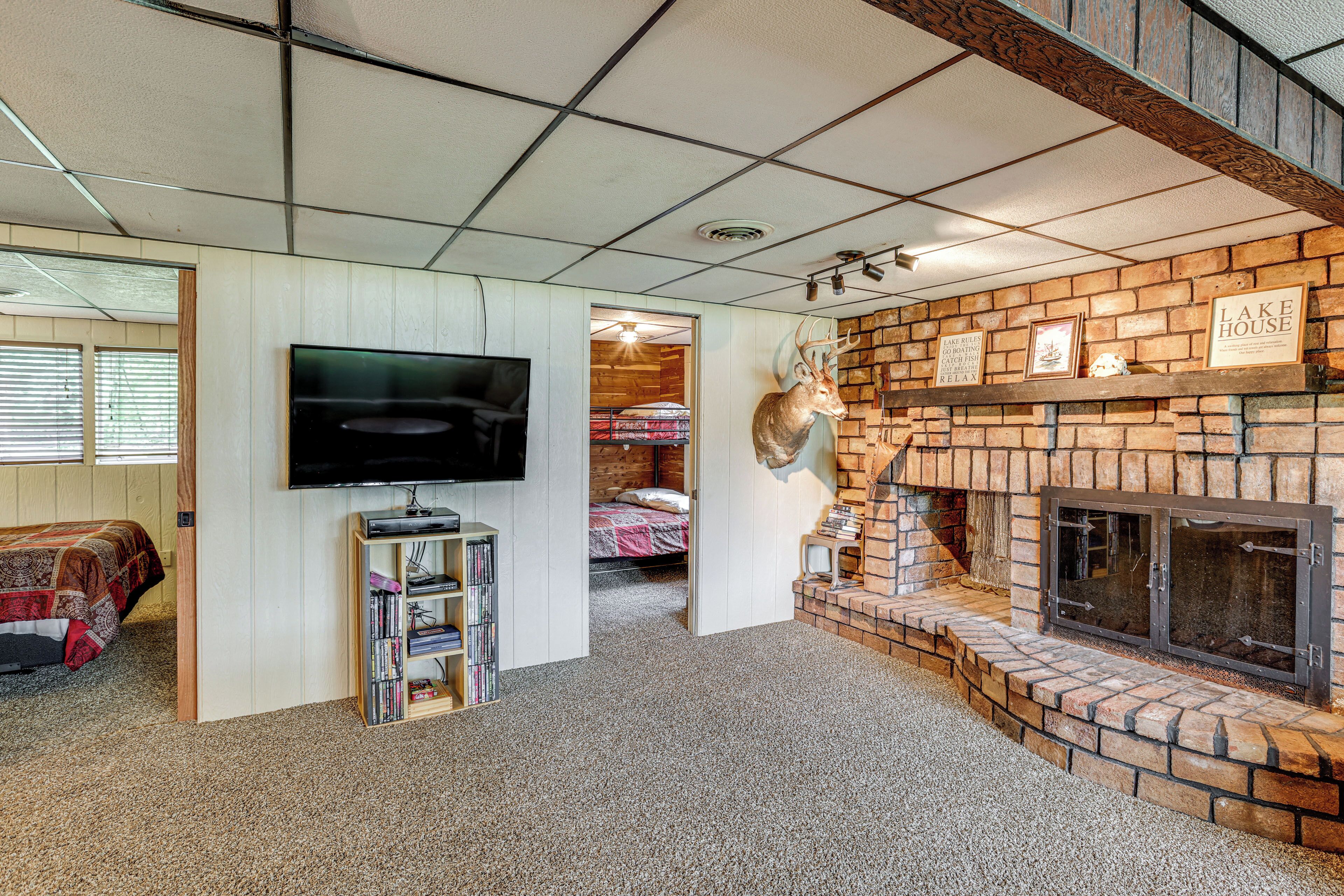 Een kamer met een open haard, een opgehangen hertenhuid, een televisie en een boekenkast.