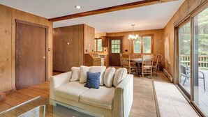 A cozy living room with a sofa and chairs, wooden walls, and large windows. - White Mountain Retreat! 3 Mi to Cannon Mountain (Franconia)