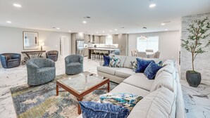 A spacious living room with a sofa, armchairs, and a coffee table. There is a kitchen area in the background with a dining set. - < 1 Mi to Sau: Newly Renovated Home w/ Yard! (Magnolia)