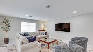 A modern living room with a sofa, coffee table, and armchairs.