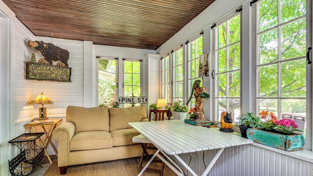 A cabin interior with a sofa, a table, and a sign that reads "Welcome to the Cabin."