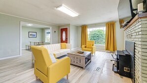 A living room with a sofa, armchairs, a coffee table, and a fireplace. - Walk to Beach: Cozy Home w/ Deck in Smith River! (Smith River)