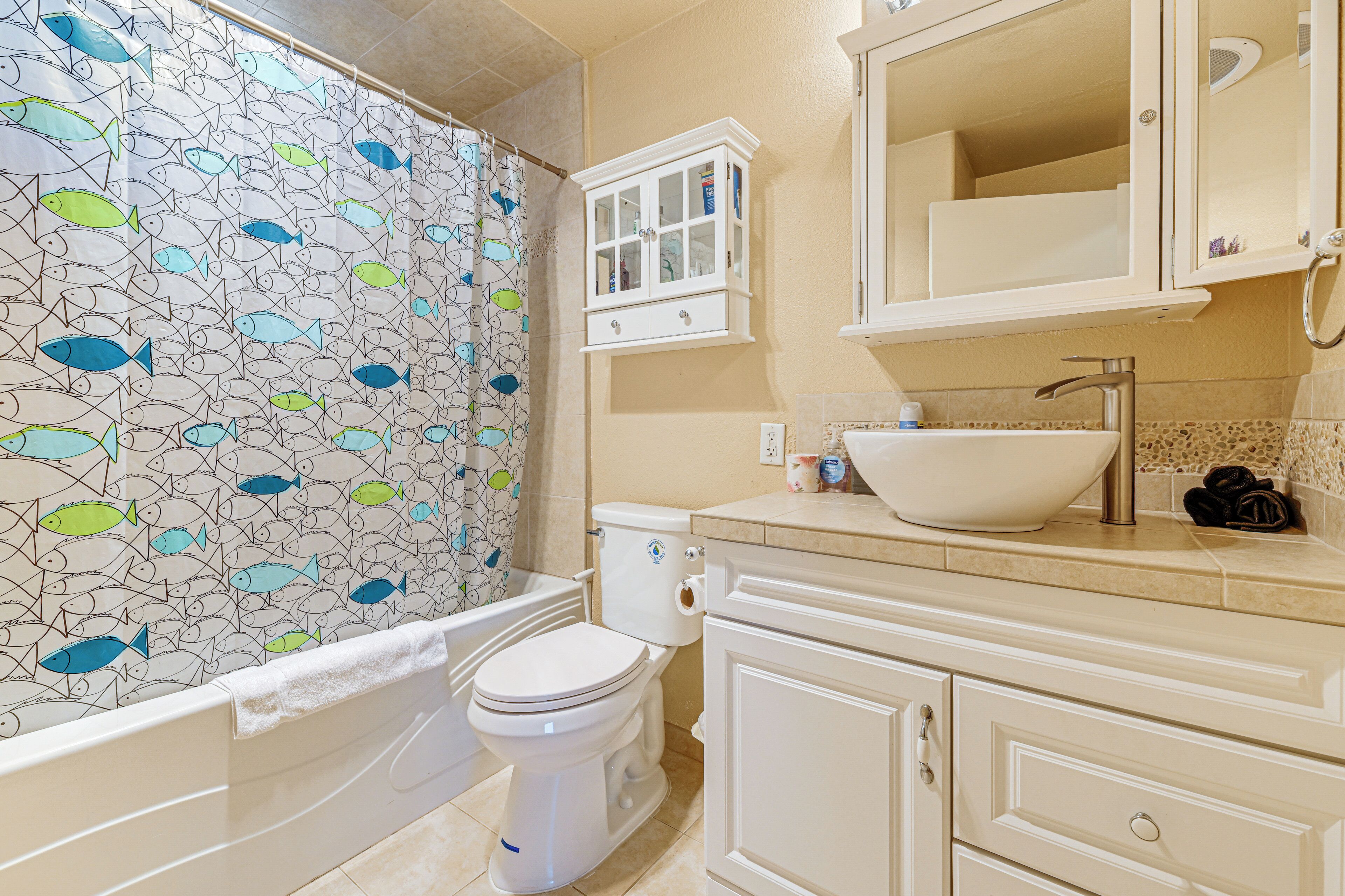 A bathroom with a toilet, bathtub, and sink.