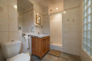 A bathroom with a toilet, sink, mirror, shower, and a window with decorative glass. - Holiday Home 'Le Crévy - Le Chateau - 8 Pers' with Private Terrace, Shared Garden and Wi-Fi (Val d'Oust)