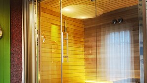 Ein modernes Badezimmer mit einer gläsernen Dusche, Holzpaneelen und Fliesenboden.