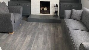 A modern living room with a fireplace, grey sofas, and dark cabinets. - Cortoon Inn, Family Room 1 (1DBL +2SGL) (Tuam)