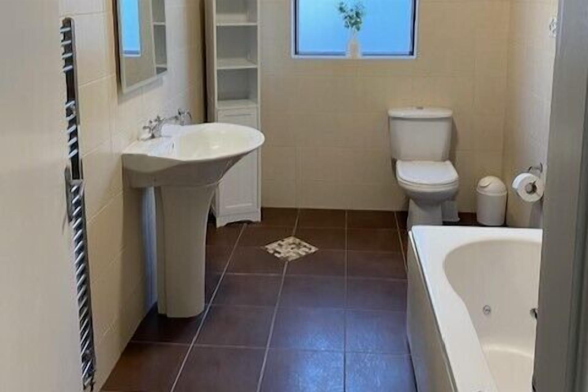 Un baño con lavamanos, inodoro y bañera.