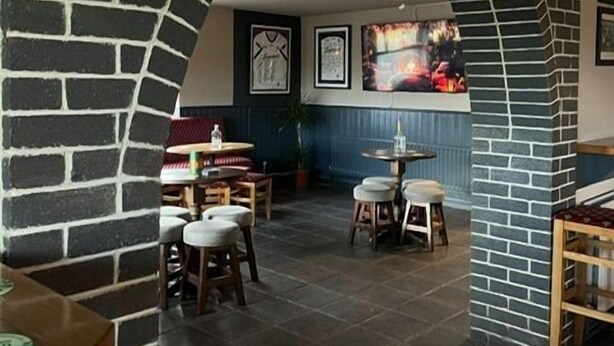 A restaurant interior with brick arches, tables, chairs, and a counter. - Cortoon Inn, Family Room 1 (1DBL +2SGL) (Tuam)