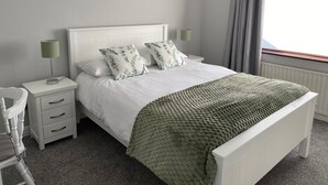 A neatly arranged bedroom with a bed, bedside tables, a lamp, and a window with curtains. - Cortoon Inn, Twin Room 3 (2 SGL) (Tuam)