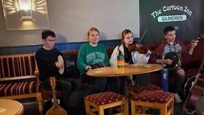 A group of people seated around a table in a restaurant with a sign reading "The Cartoon Inn Gilmores".