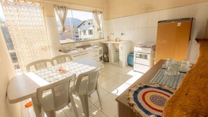 Una cocina compacta con comedor, estufa a gas y refrigerador.