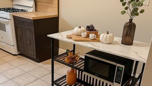 Une cuisine avec un îlot central, un four à micro-ondes et une cuisinière.