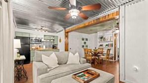 A modern living room with a grey sofa, a wooden coffee table, and a ceiling fan.