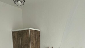 Een slaapkamer met een bed, een kledingkast en een nachtkastje.