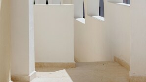 A corridor with white walls and arches, leading to a room with a tiled floor. - Maison Sirolo (Sirolo)