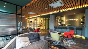 Een moderne lounge met een bar, zitplaatsen en een bord met de tekst 'alleen goede sfeer'.