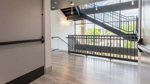 A modern interior with a staircase, wooden flooring, and a view of the outside. - Music Row Magic - Pool + Gym + Downtown (Nashville)