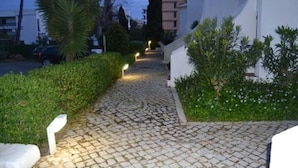 Un sendero adoquinado bordeado de vegetación y edificios.