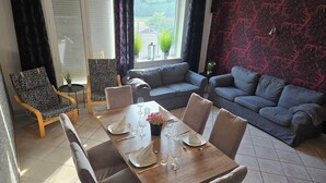 A dining area with a wooden table set for four, surrounded by grey upholstered chairs.