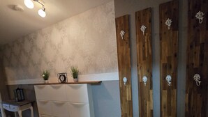 A kitchen with a white countertop, a small table, and a wooden wall panel with decorative handles.