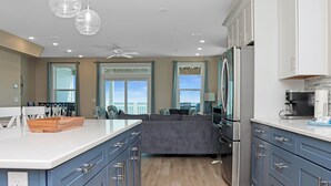 Una cocina moderna con una isla grande, electrodomésticos integrados y vistas al exterior.