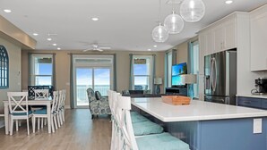 Una cocina moderna con una isla grande, electrodomésticos de acero inoxidable y un comedor con vistas.
