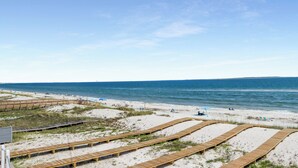 Una playa con pasarelas de madera y sillas de playa.