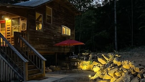 A wooden cabin with a porch, outdoor seating, and a stone wall. - Cozy cabin in welcoming Speedwell with WiFi, AC (Speedwell)