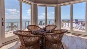 A corner room with a view of the ocean, wicker furniture, and a wooden ceiling. - 5BR North Captiva Estate Sleeps 19 with Pool & Dock (Captiva)