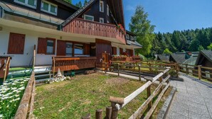 A chalet-style building with a wooden balcony, a stone pathway, and a flower garden. - GuestHost - House of Hope (Camporosso)