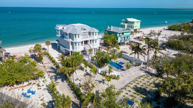 Una propiedad frente a la playa con varias edificaciones, piscina y acceso directo a la costa.