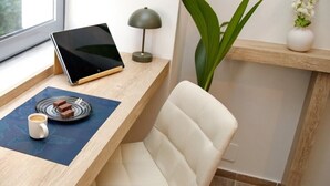 Ein moderner Arbeitsplatz mit Schreibtisch aus Holz, einem Laptop, einer Kaffeetasse und einer Schokoladentafel.